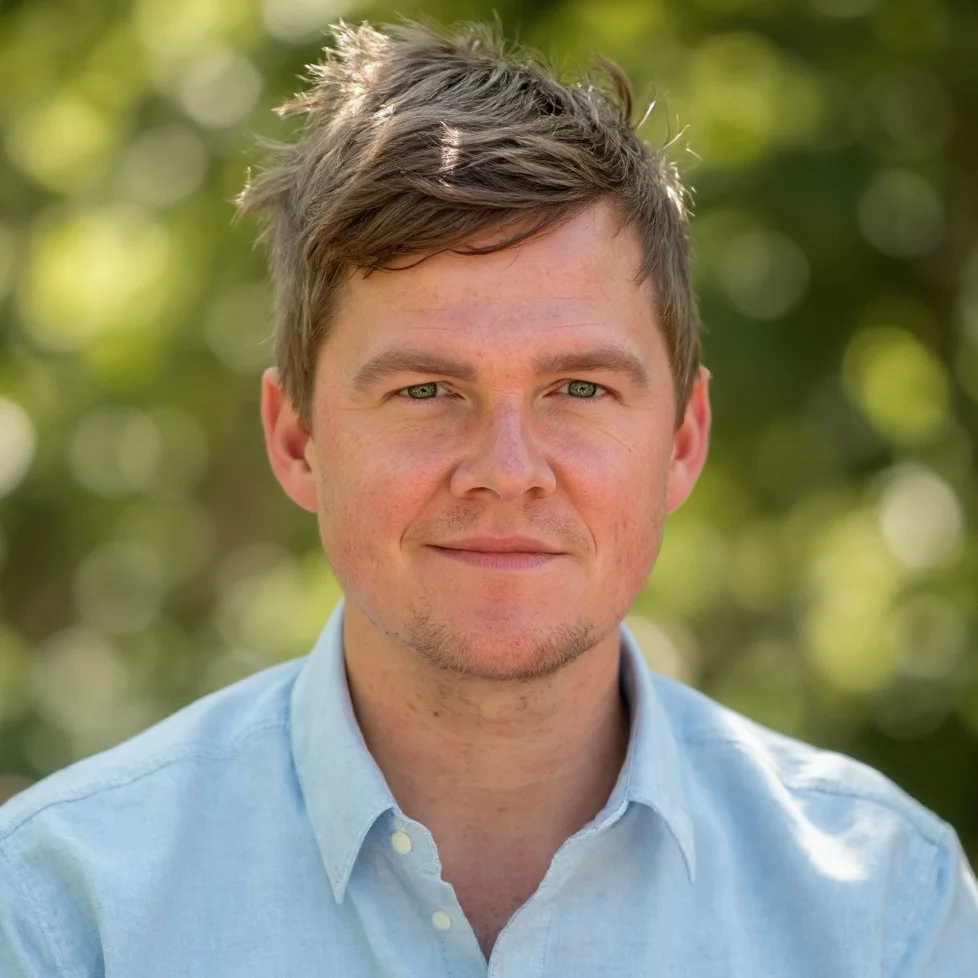 Portrait of Ben Peterson outdoors, wearing a light blue shirt